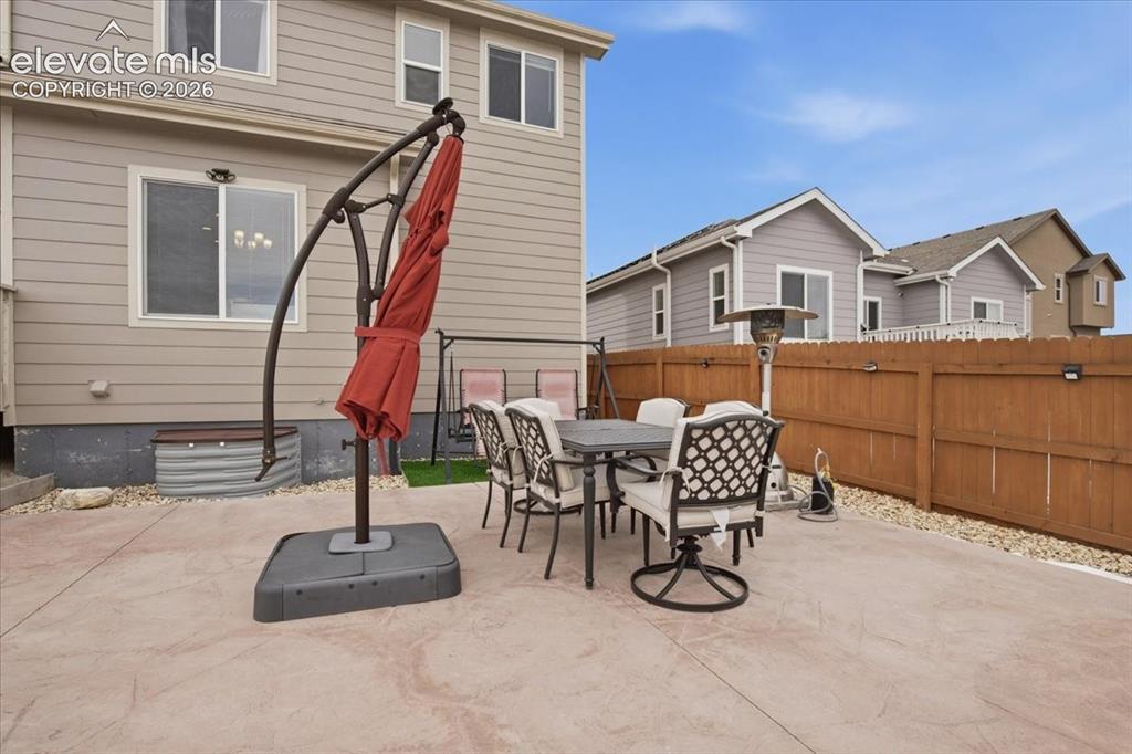 Image 29 of 31: Expansive concrete patio with decorative finish, private wood fencing, and 