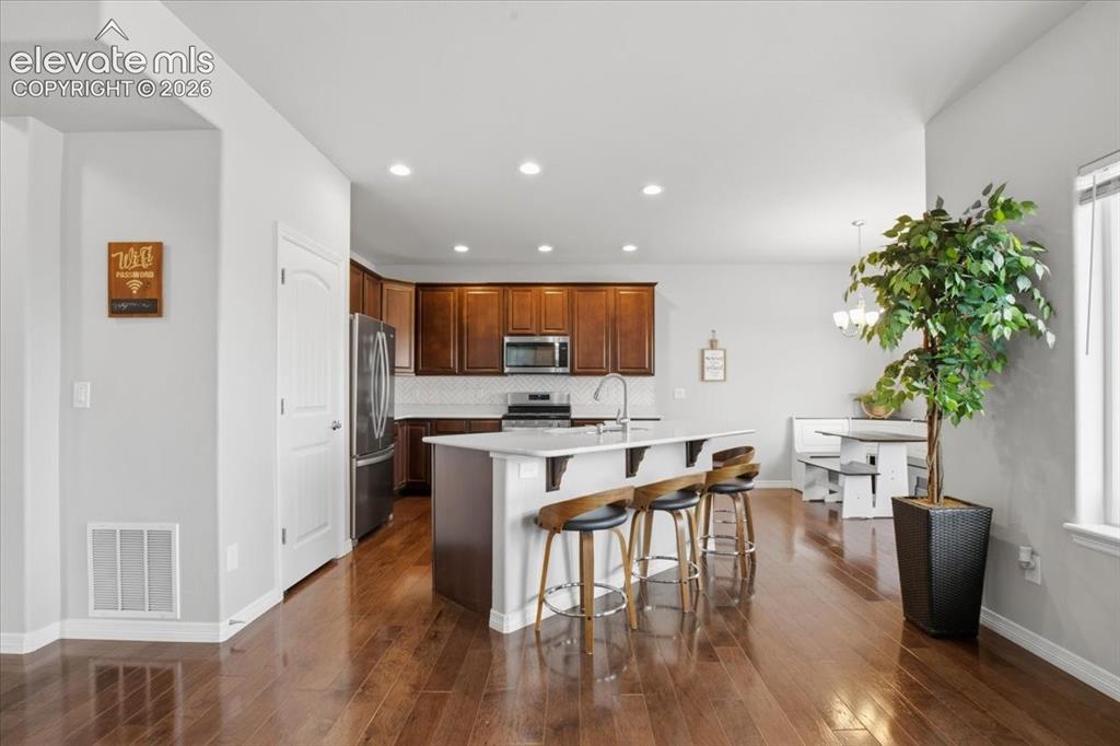 Image 5 of 31: Open-concept kitchen featuring wood-finish flooring, recessed lighting, a k