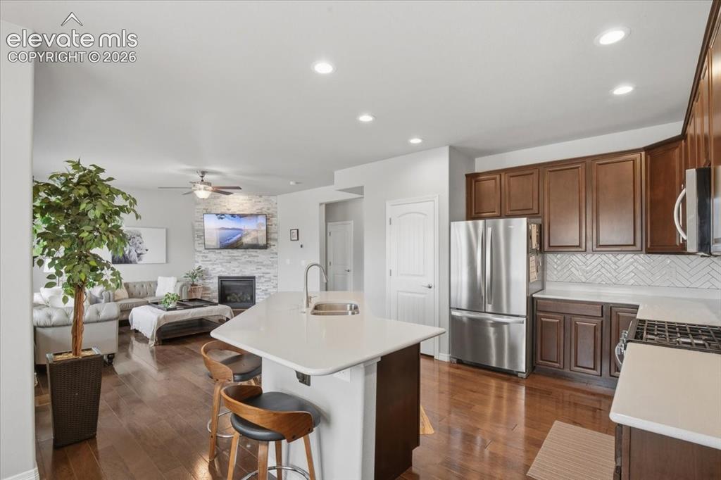 Image 6 of 31: Hardwood-finish flooring, recessed lighting, and a kitchen island with seat