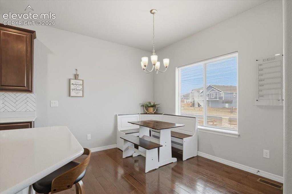 Image 9 of 31: Hardwood-finish flooring, white countertops, dark wood cabinetry, white her