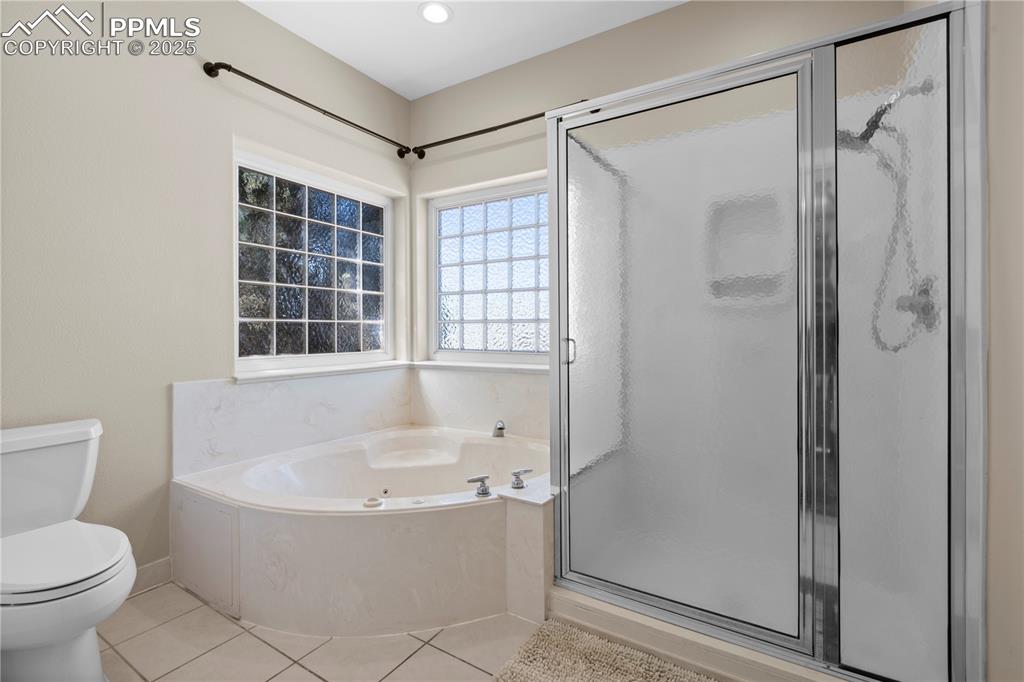 Image 12 of 45: Full bath featuring a garden tub, a stall shower, and tile patterned floors