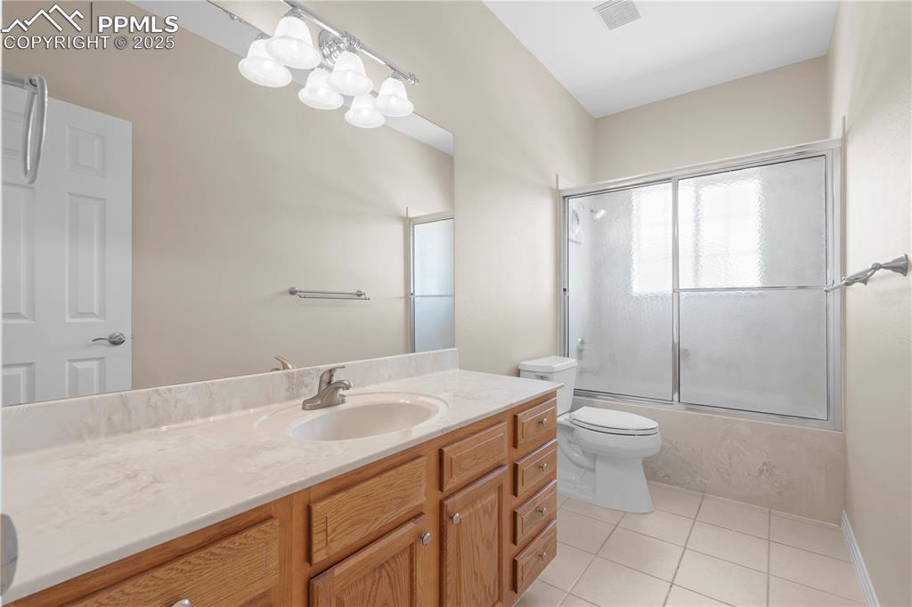 Image 13 of 45: Full bathroom featuring vanity, tile patterned floors, and enclosed tub / s