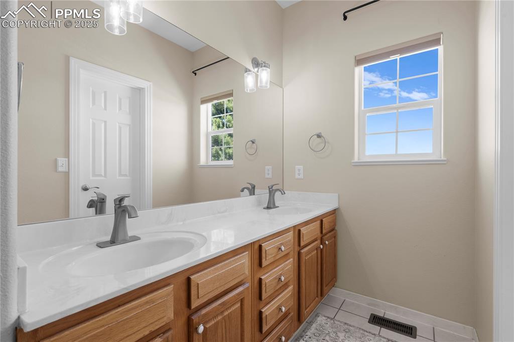 Image 15 of 45: Bathroom with double vanity and tile patterned floors