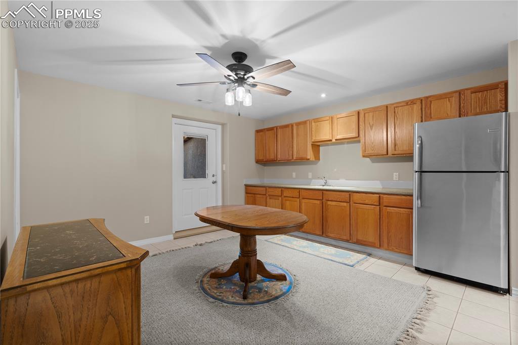 Image 20 of 45: Kitchen featuring freestanding refrigerator, light tile patterned floors, a