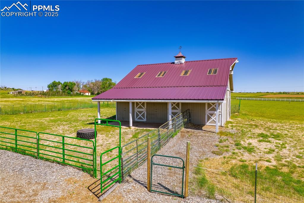 Image 35 of 45: Back of house with an exterior structure, an outdoor structure, a metal roo