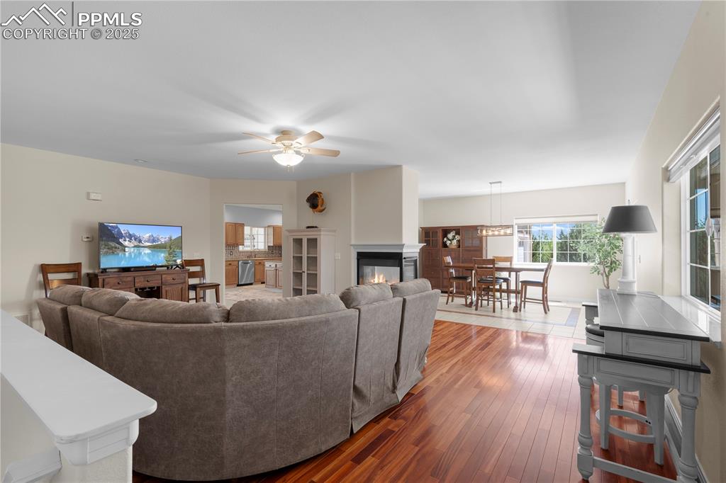 Image 6 of 45: Living room with hardwood / wood-style flooring, ceiling fan, and a multi s