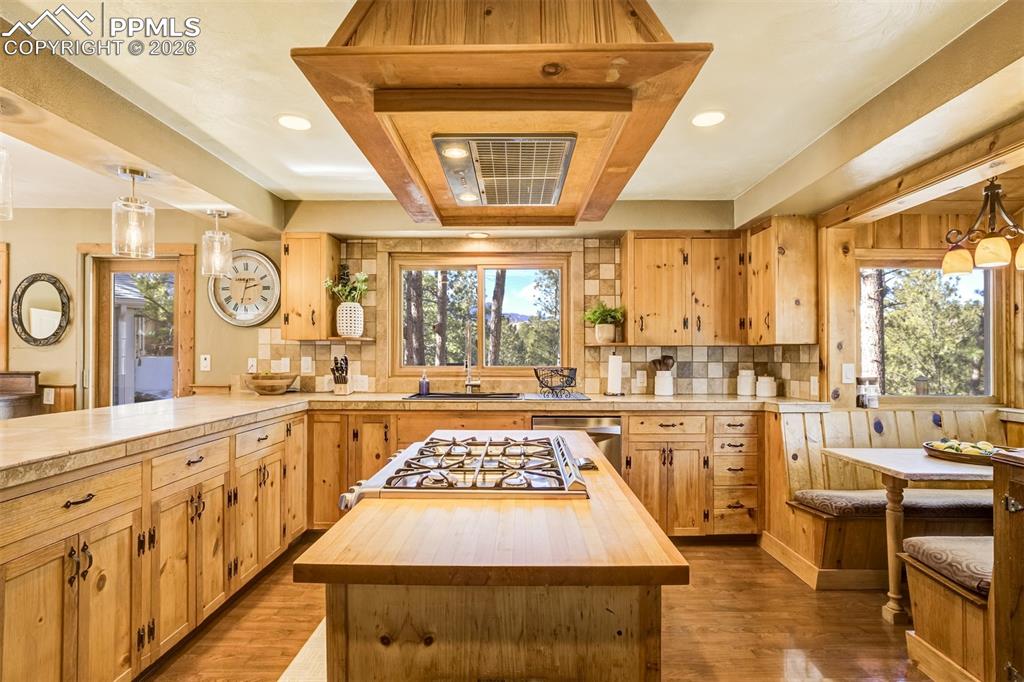 Image 15 of 50: Kitchen featuring pendant lighting, butcher block countertops, a kitchen is