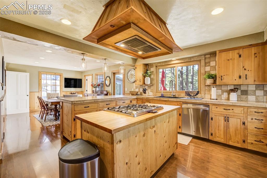 Image 16 of 50: Kitchen adjacent to large dining with stainless steel appliances, gas range