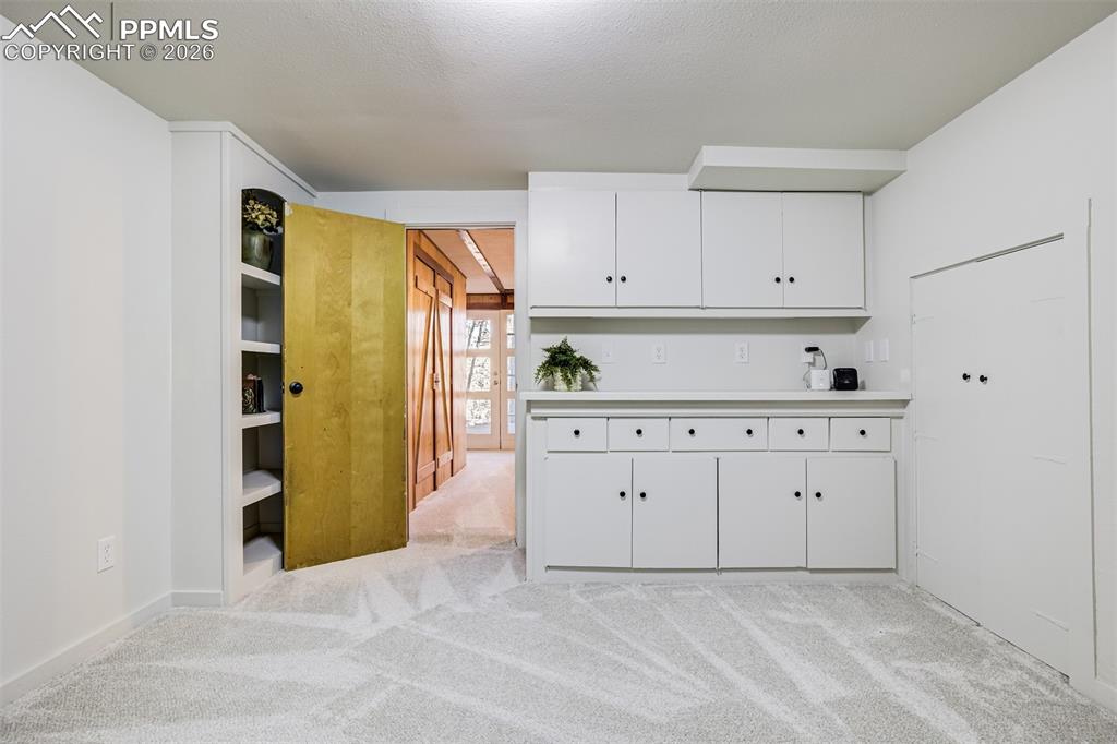 Image 31 of 50: Office in basement with built ins. Would make a great craft room/playroom, 