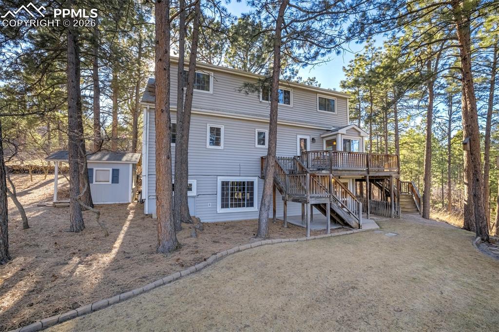 Image 46 of 50: Rear view of property featuring stairs and a wooden deck