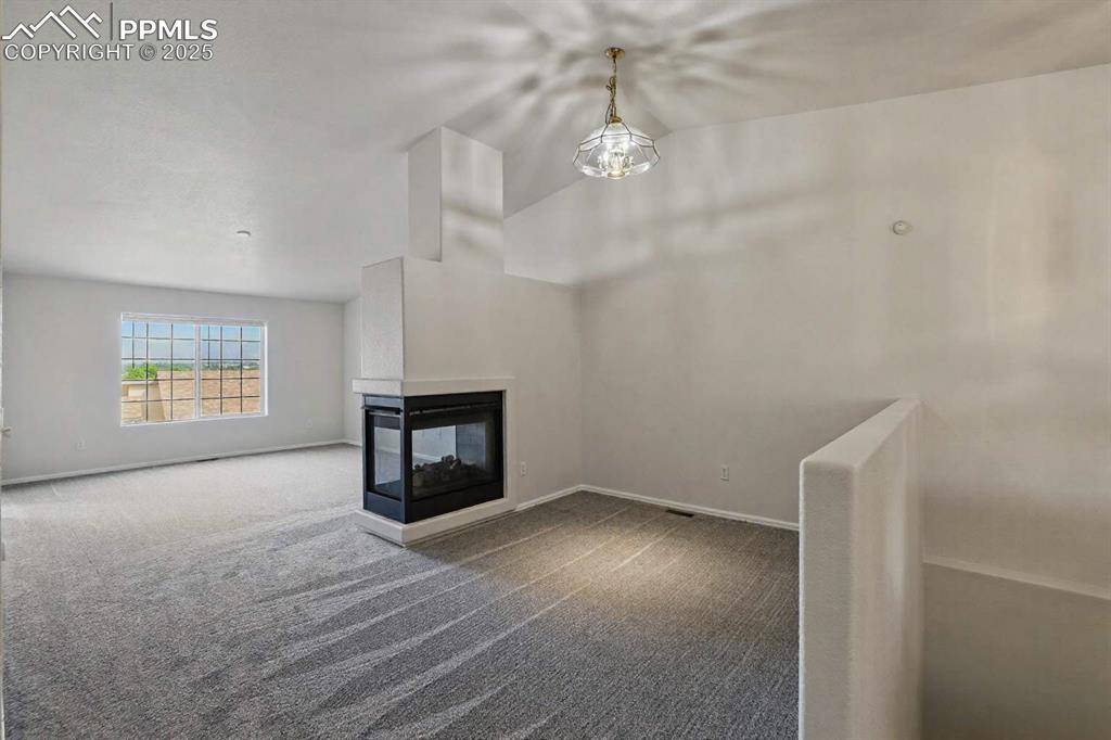 Image 15 of 50: Formal dining area with 3 sided fireplace between dining room & living room
