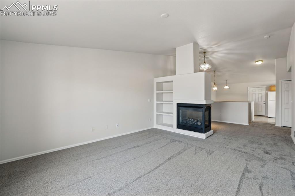 Image 16 of 50: 3 sided fireplace between formal dining room & formal living room