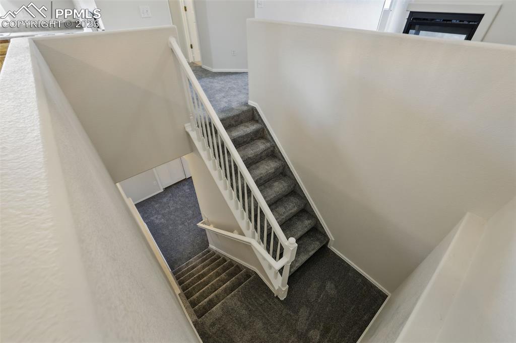 Image 35 of 50: Stairs with carpet floors to basement living area