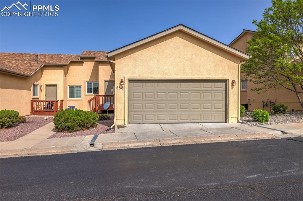 Image 4 of 50: View of front of house with stucco siding, an attached 2 car garage