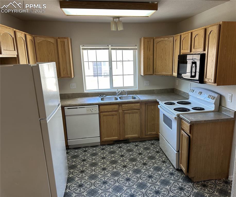 Image 8 of 50: Kitchen with white appliances and new vinyl flooring