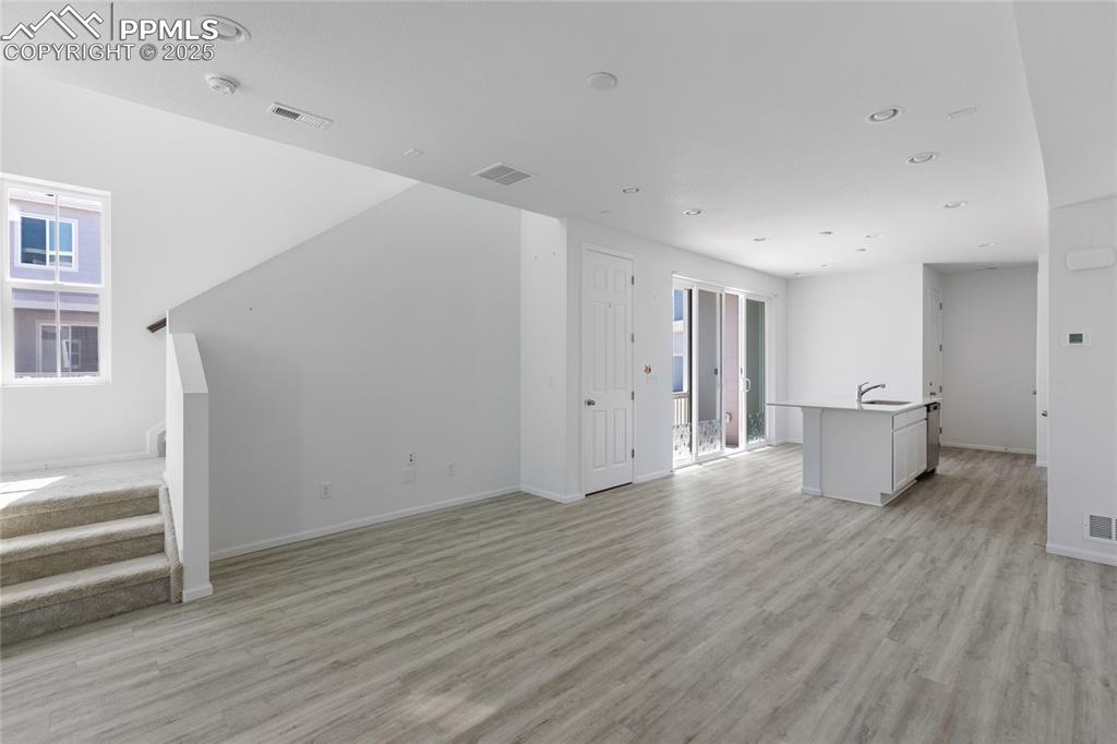 Image 6 of 37: Large open living room/kitchen area with LVP flooring