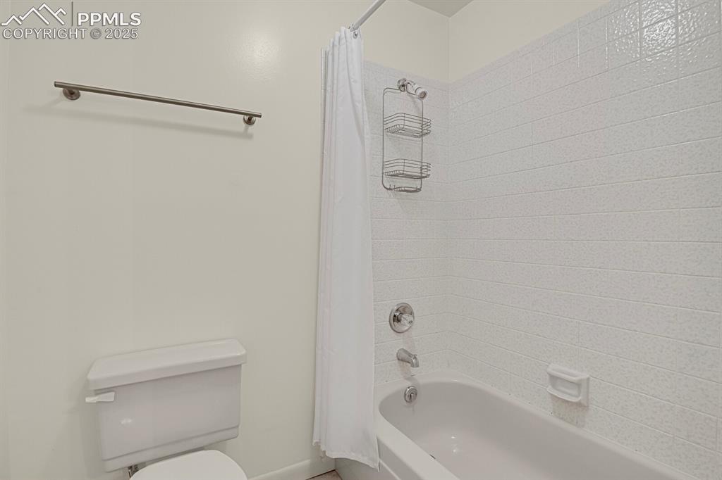 Image 14 of 23: Bathroom featuring shower / tub combo with curtain and toilet