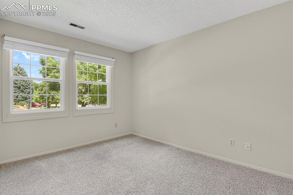 Image 15 of 23: Carpeted spare room with a textured ceiling and baseboards