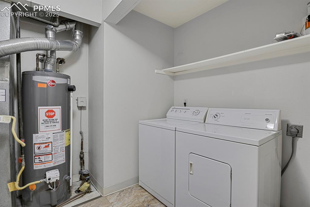 Image 18 of 23: Laundry room with gas water heater and washer and clothes dryer