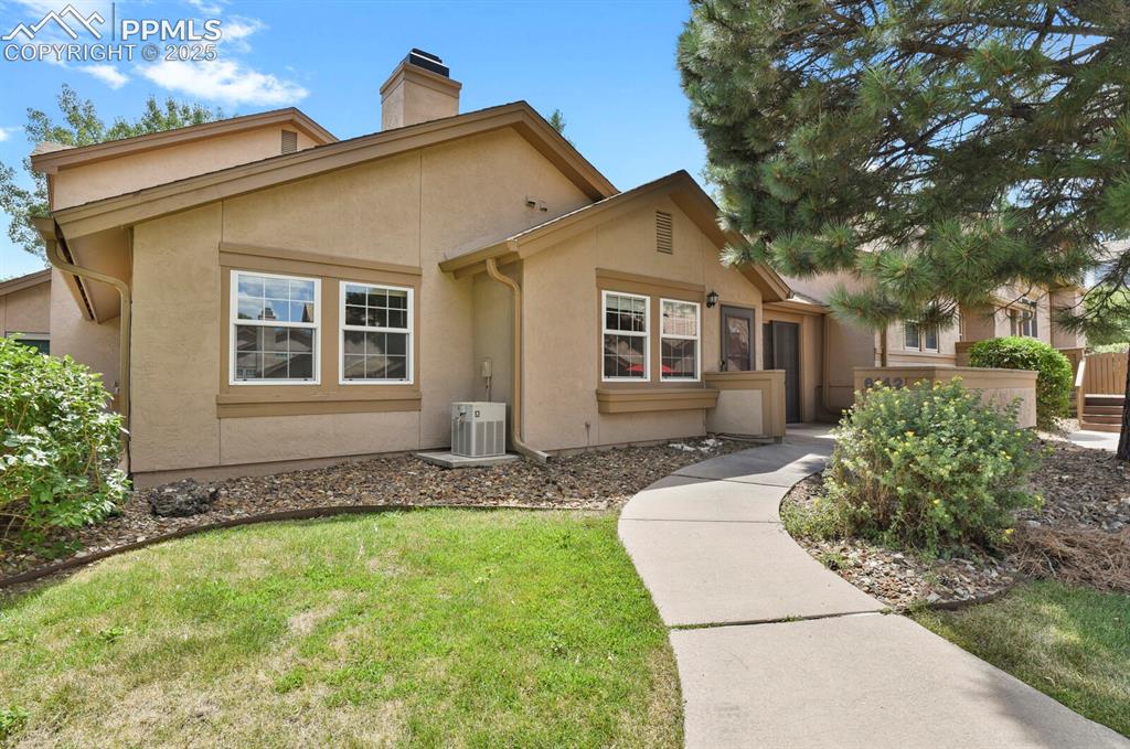 Image 2 of 23: View of front of house featuring stucco siding, a chimney, and a front yard