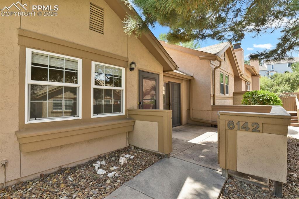 Image 3 of 23: Property entrance with a patio area, stucco siding, and a chimney