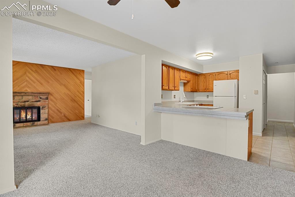 Image 8 of 23: Kitchen featuring wood walls, light colored carpet, light countertops, free