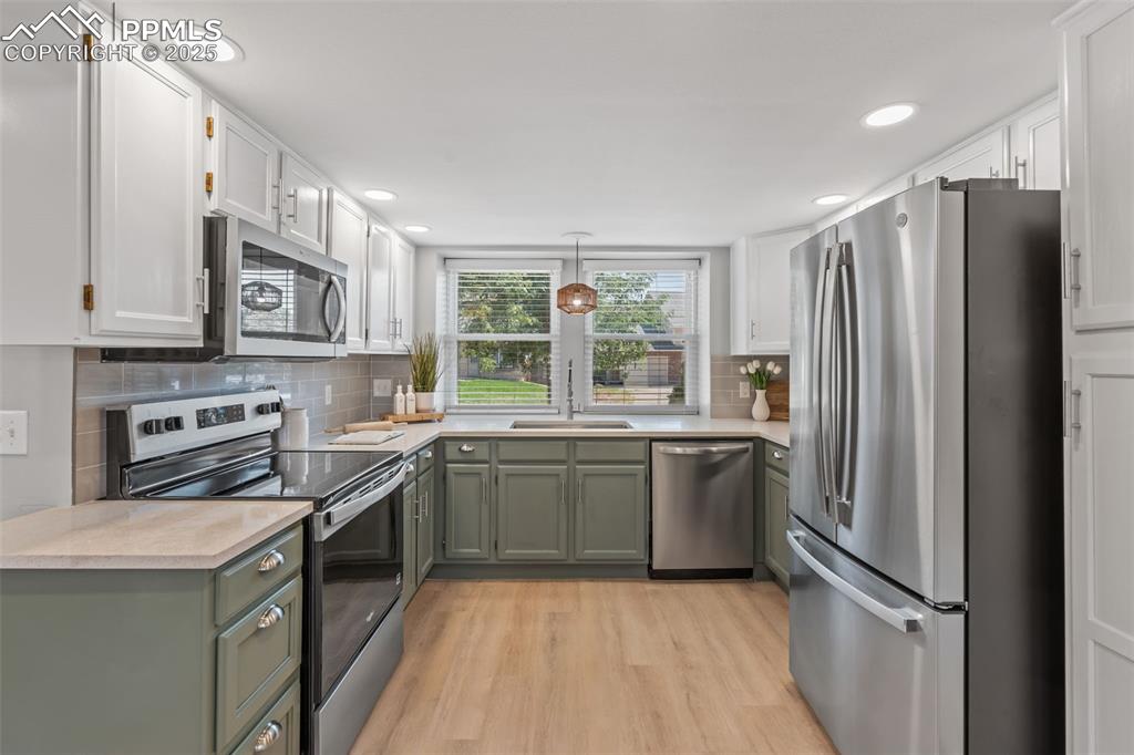 Image 12 of 40: Kitchen featuring stainless steel appliances, light wood finished floors, w