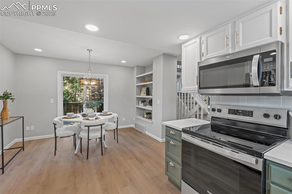 Image 16 of 40: Kitchen featuring appliances with stainless steel finishes, green cabinets,