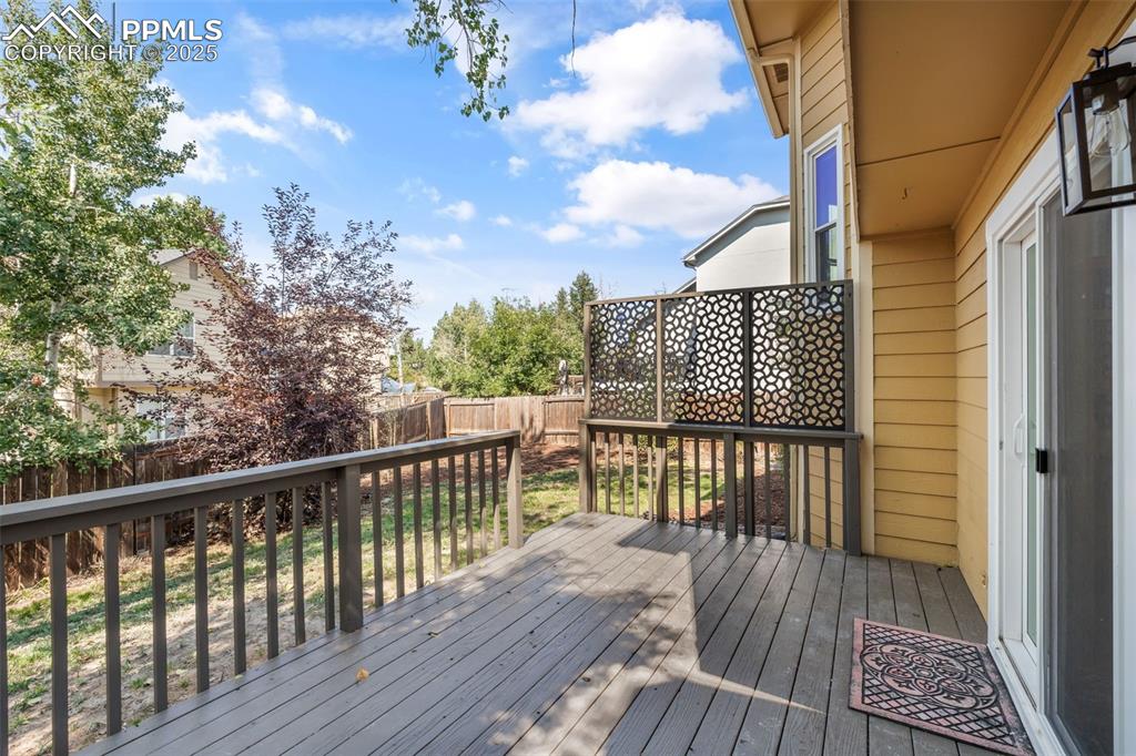 Image 17 of 40: Wooden deck with a fenced backyard