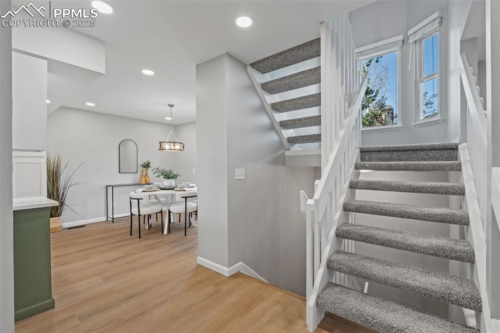 Image 18 of 40: Stairs with wood finished floors and recessed lighting