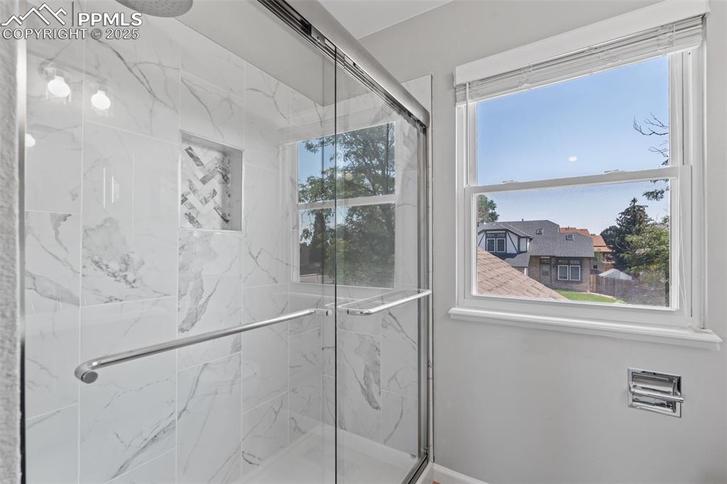 Image 23 of 40: Bathroom with a marble finish shower