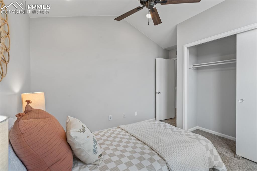 Image 26 of 40: Carpeted bedroom with lofted ceiling, a ceiling fan, and a closet