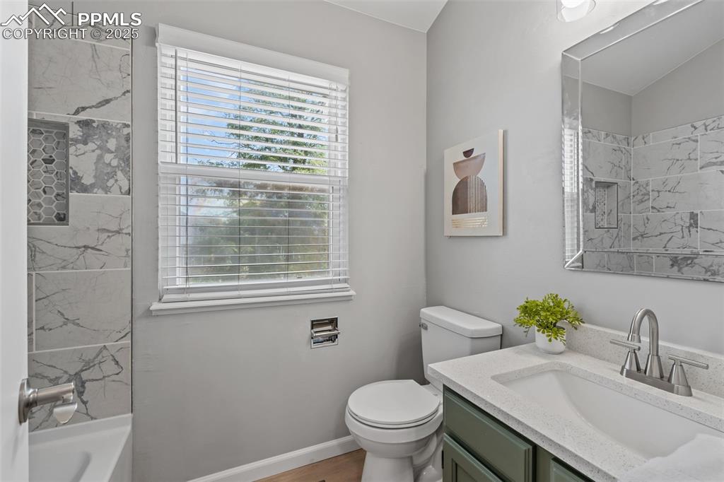 Image 27 of 40: Bathroom with vanity, tub / shower combination, and light wood-style floori