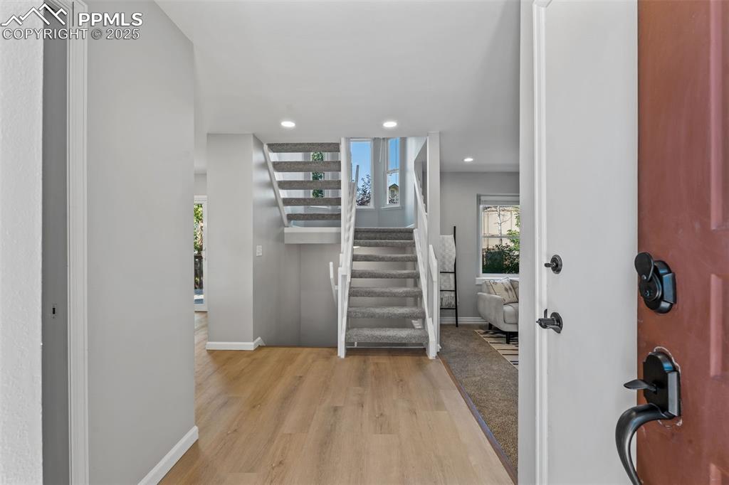 Image 3 of 40: Foyer featuring light wood finished floors, stairs, and recessed lighting