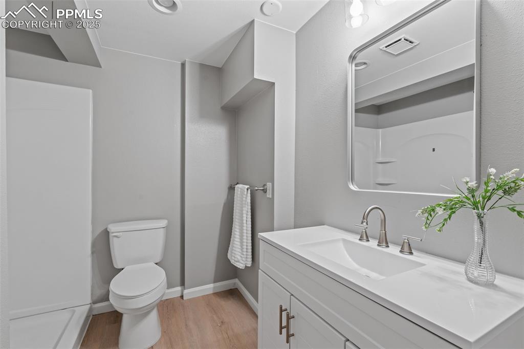 Image 32 of 40: Bathroom featuring light wood finished floors and vanity