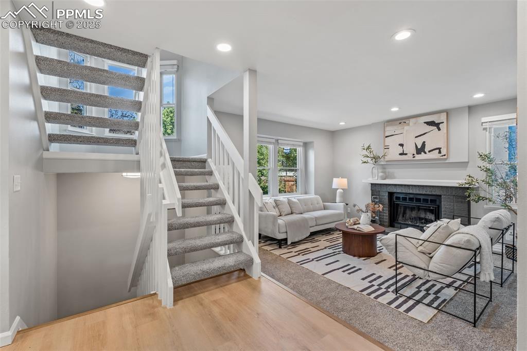Image 4 of 40: Living room with light wood-style flooring, a fireplace, stairs, and recess