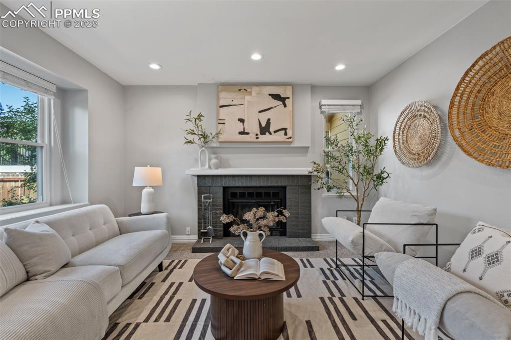 Image 6 of 40: Living room with carpet, a fireplace with raised hearth, and recessed light