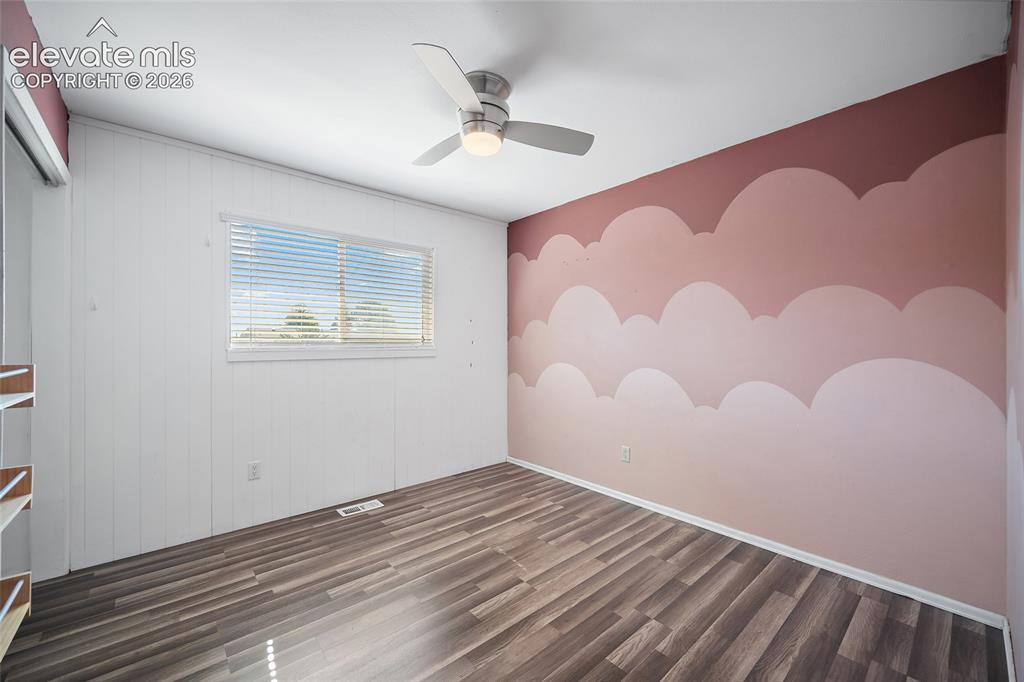 Image 20 of 50: Bedrom with ceiling fan and updated flooring.