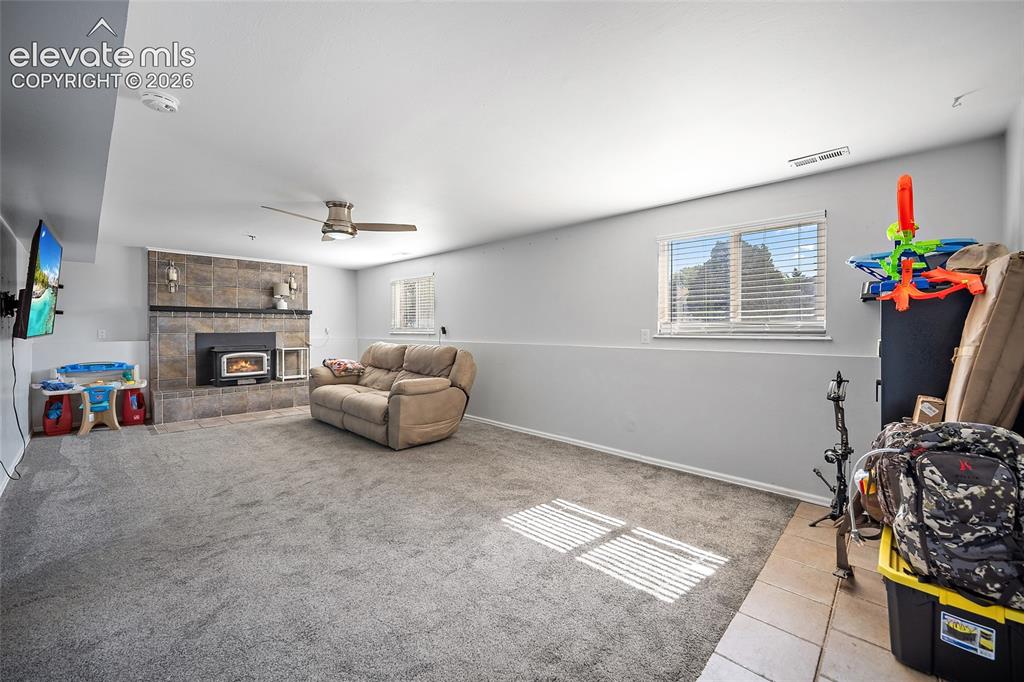 Image 27 of 50: Family room with fireplace and natural light.