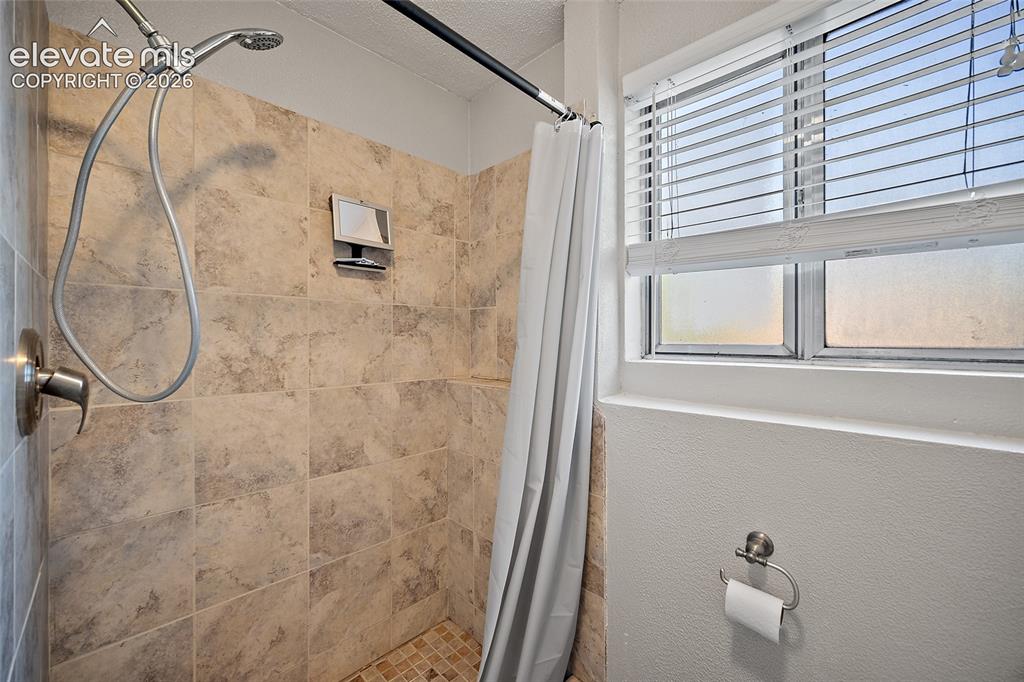 Image 29 of 50: Bathroom with updated fixtures and tiled shower.