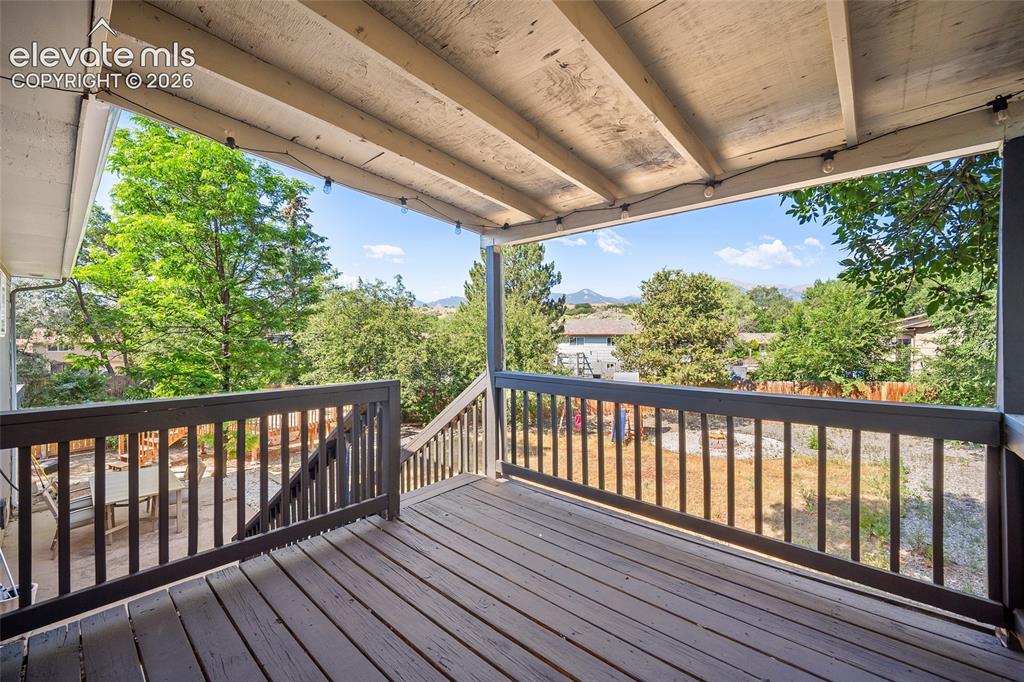 Image 31 of 50: Covered deck with views of mature trees.