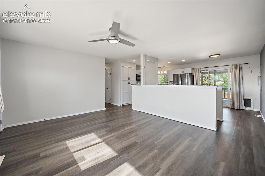 Image 6 of 50: Spacious living room with ceiling fan.