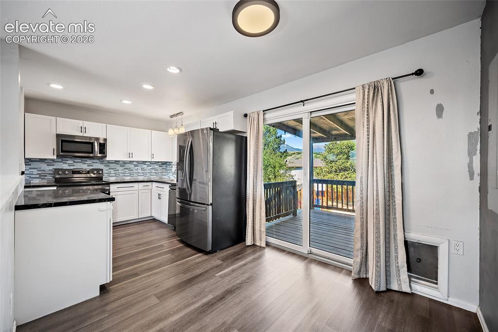 Image 8 of 50: Dining area with sliding glass door to deck.