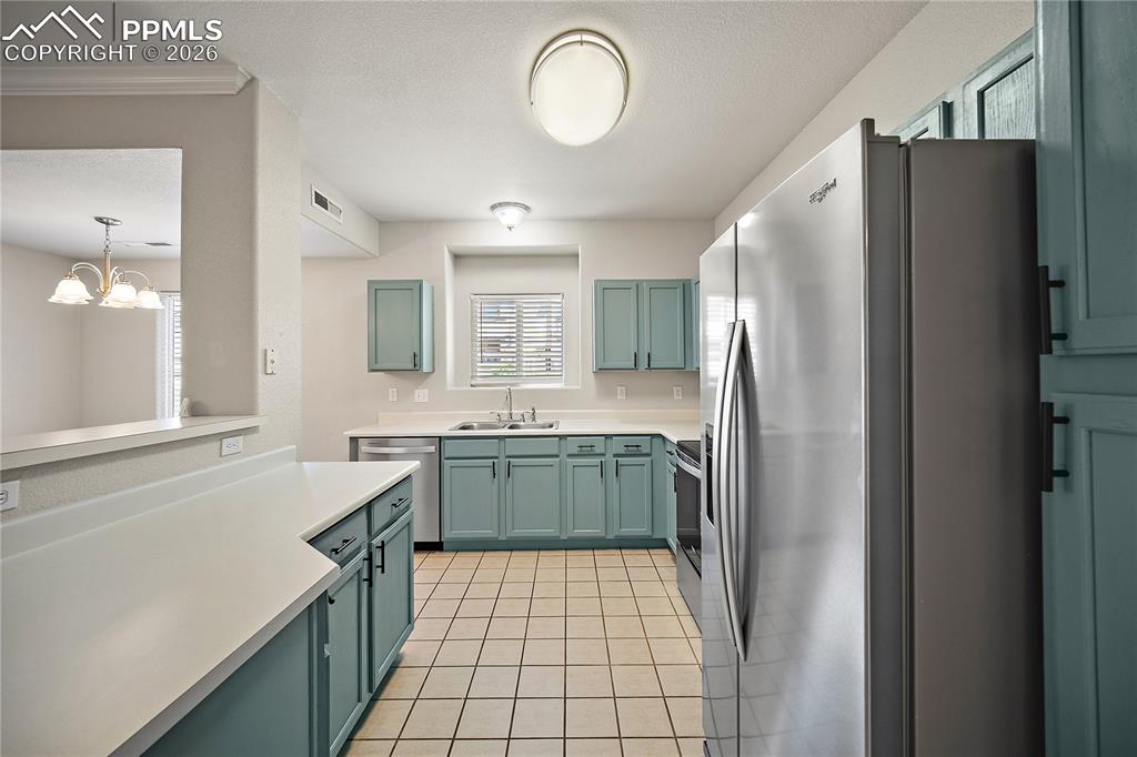 Image 14 of 31: Kitchen featuring light-toned cabinetry, stainless steel appliances, white 