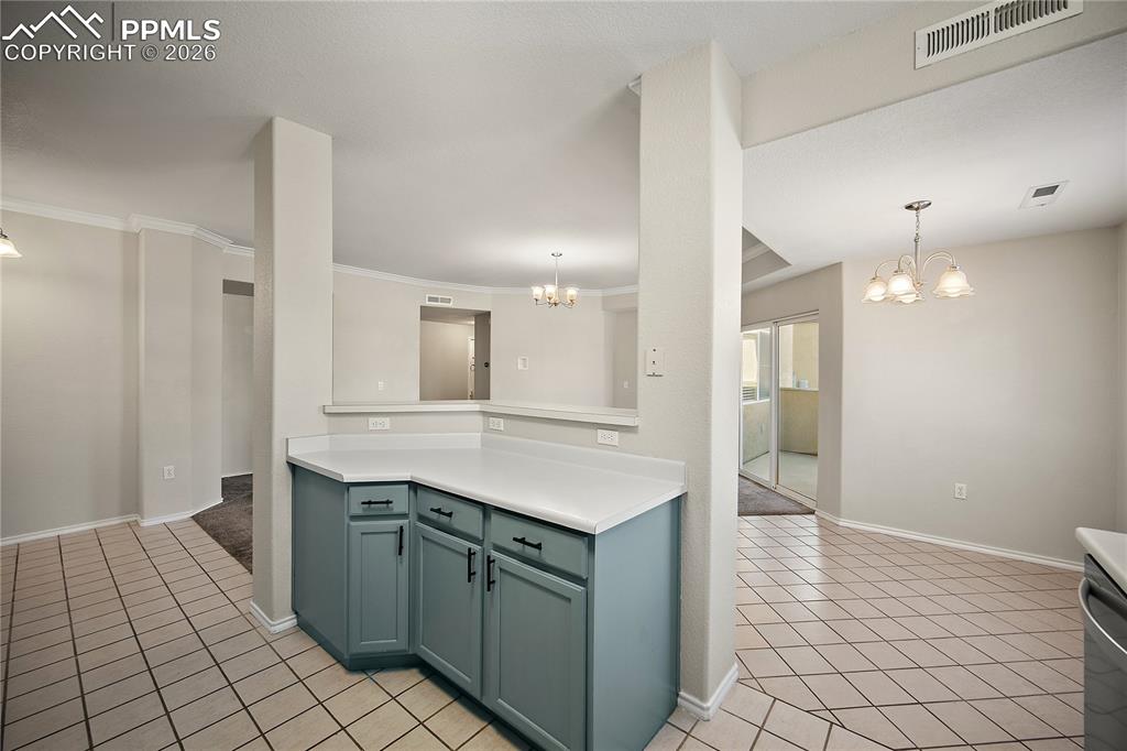 Image 16 of 31: Kitchen area featuring light blue cabinetry, white countertops, and diagona