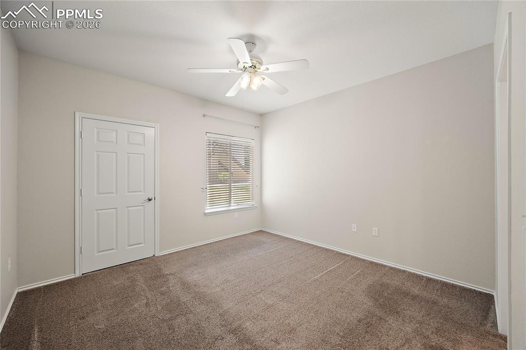 Image 18 of 31: Carpeted interior room featuring light-toned walls, a white ceiling fan wit