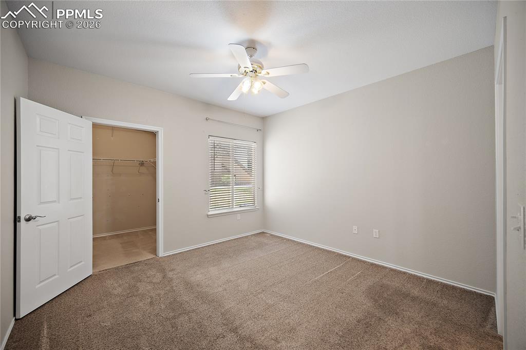 Image 21 of 31: Carpeted room featuring a ceiling fan with integrated lighting, a window wi