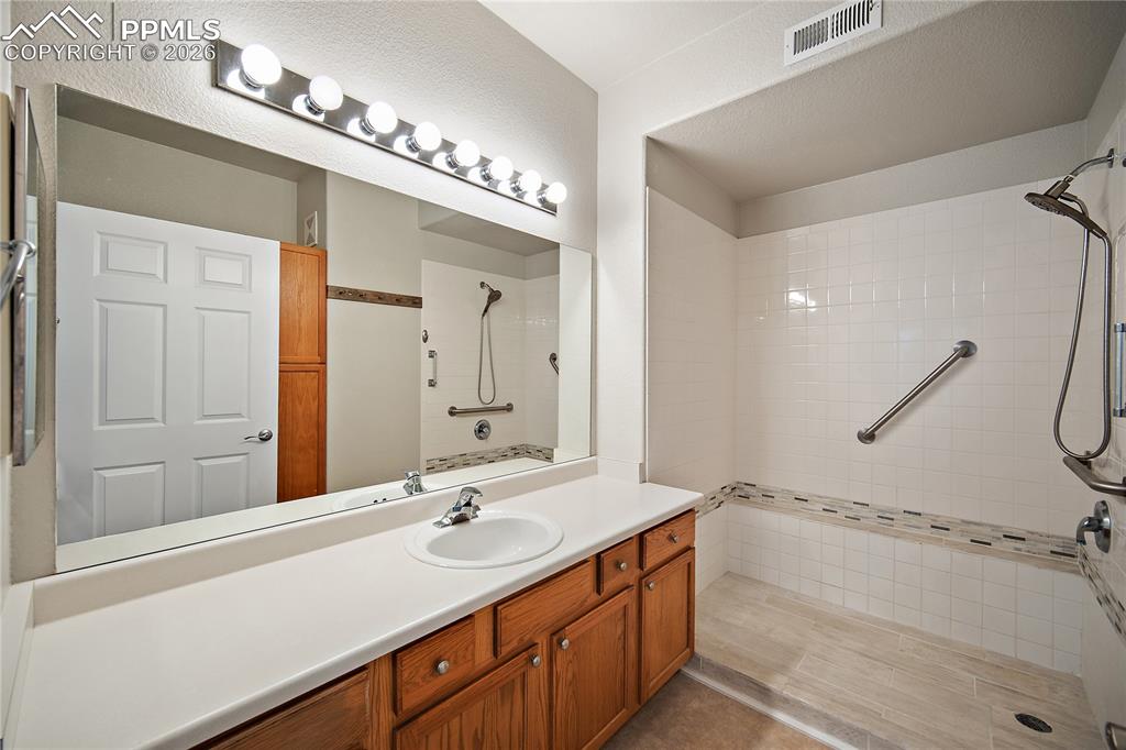 Image 22 of 31: Bathroom featuring a vanity with a white countertop, an undermount sink, an