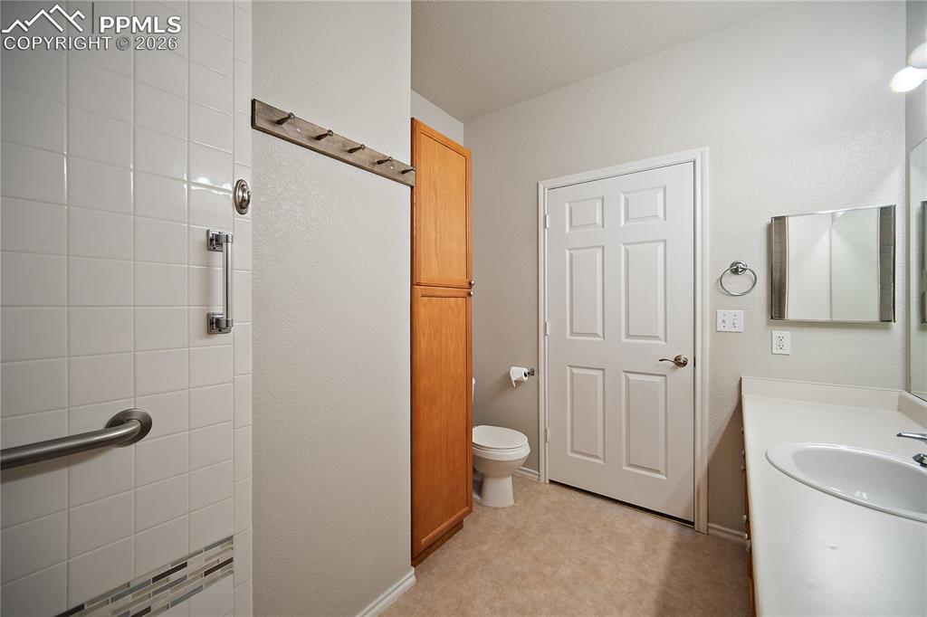 Image 23 of 31: Bathroom featuring a single vanity, built-in medicine cabinet, and a tiled 