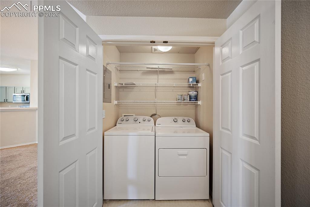 Image 24 of 31: Dedicated laundry closet featuring a top-loading washing machine, a front-l